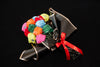 A bouquet of multicolored crew compression socks with a red ribbon, arranged in a manner resembling a traditional flower bouquet, on a black background.