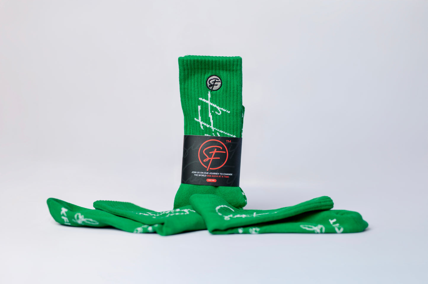 A pair of green performance crew socks with white patterns and text, displayed against a white background.