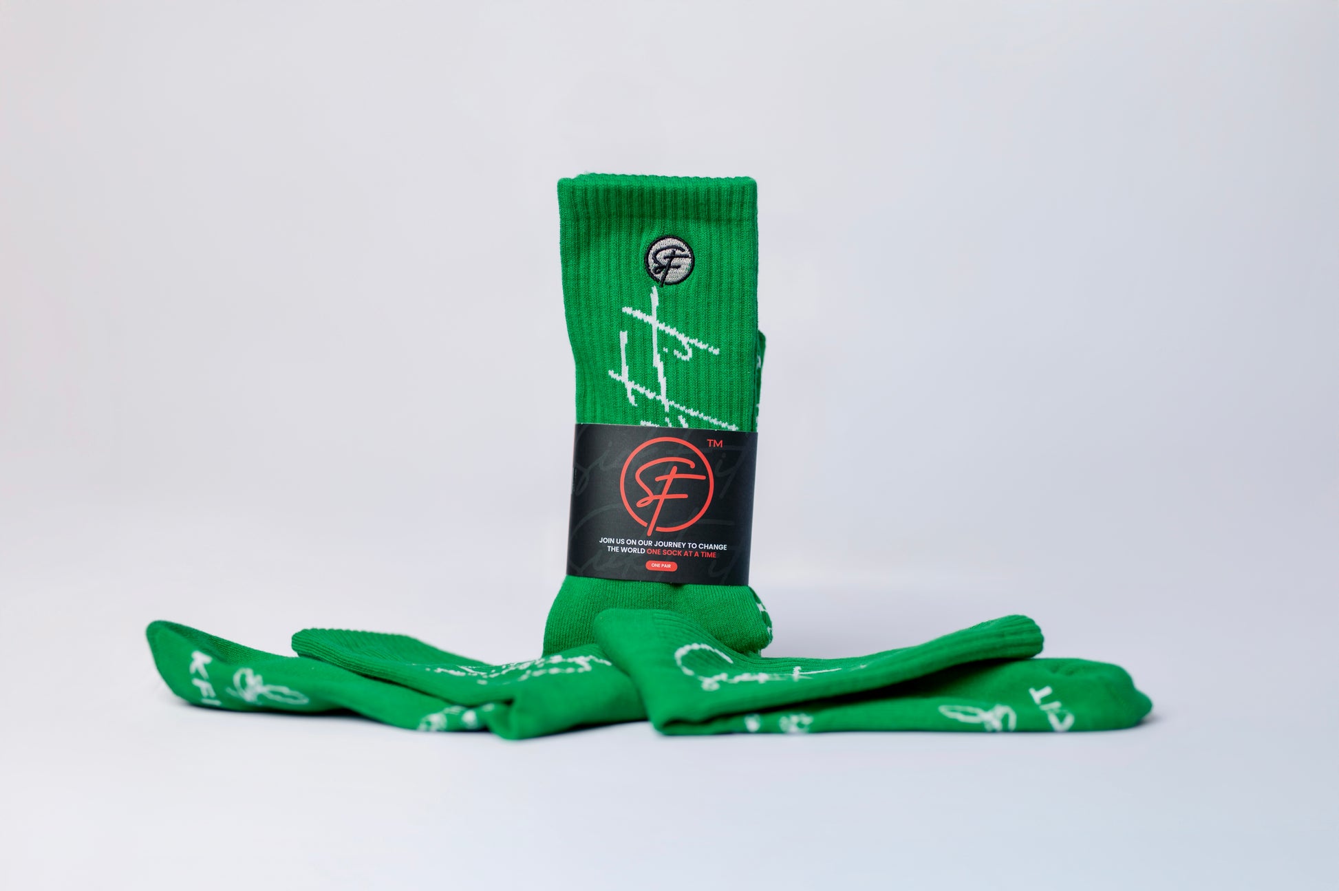 A pair of green performance crew socks with white patterns and text, displayed against a white background.