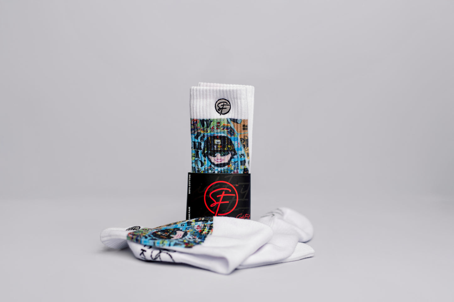 A pair of crew compression  socks with the cover art of a memoir titled 'Latina Warrior' displayed in the background.