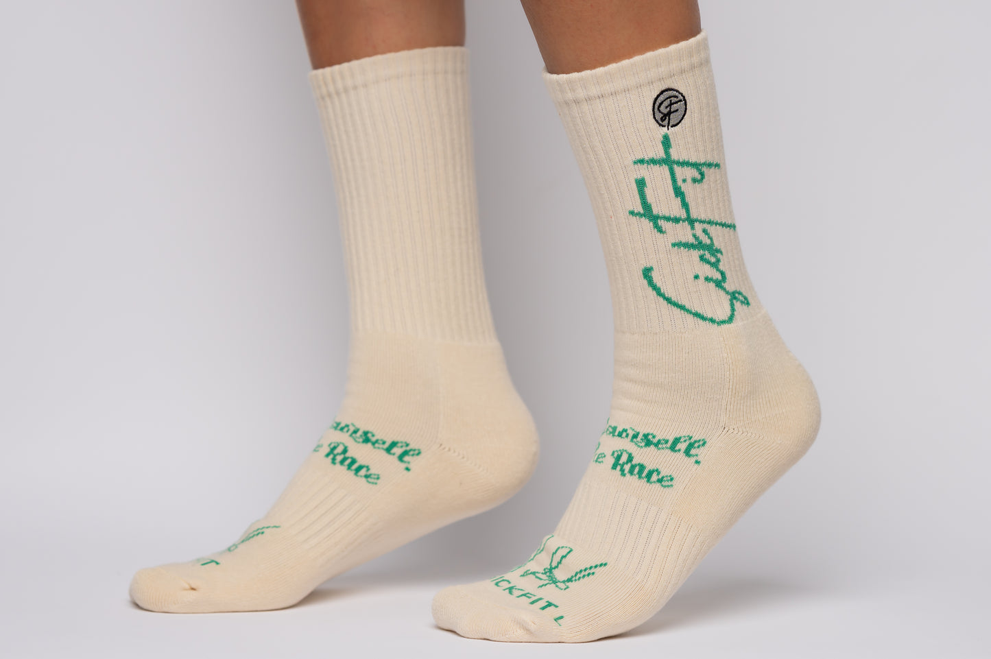 SickFit Creme socks with green text worn by a person on a light gray background