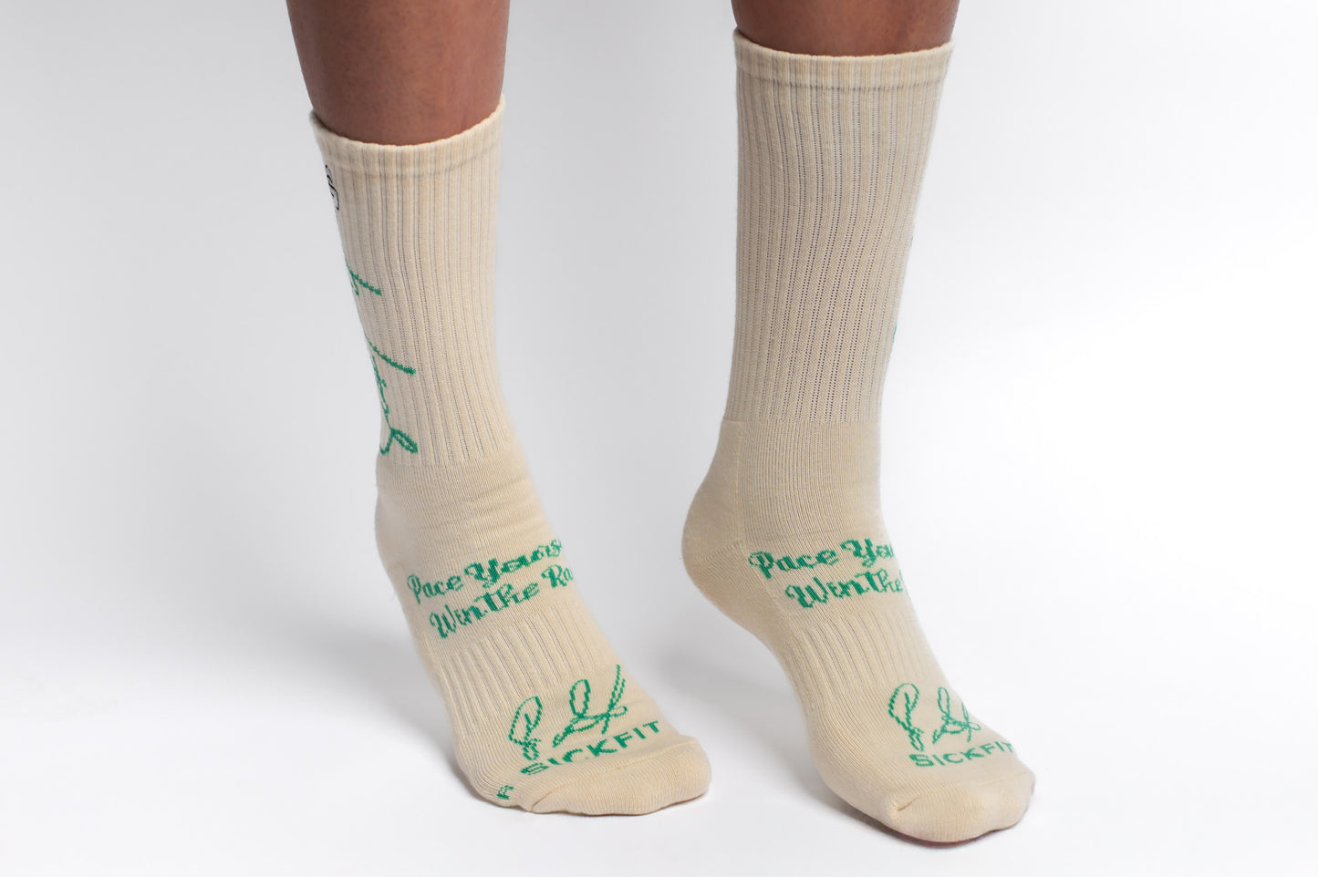 A pair of creme Sickfit Crew Compression socks with green text