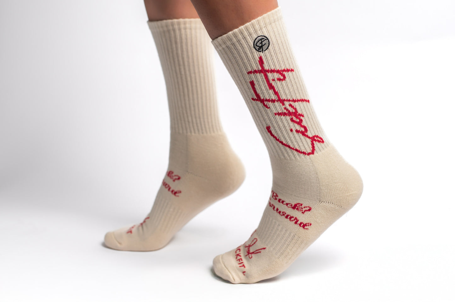 A pair of creme Sickfit Crew Compression socks with red text