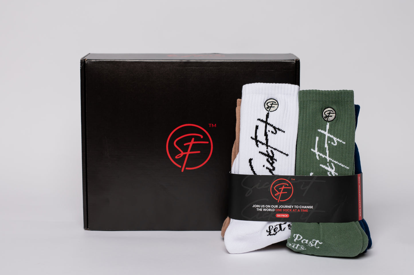 Set of crew compression socks with branding in front of a black box with a logo on a light gray background