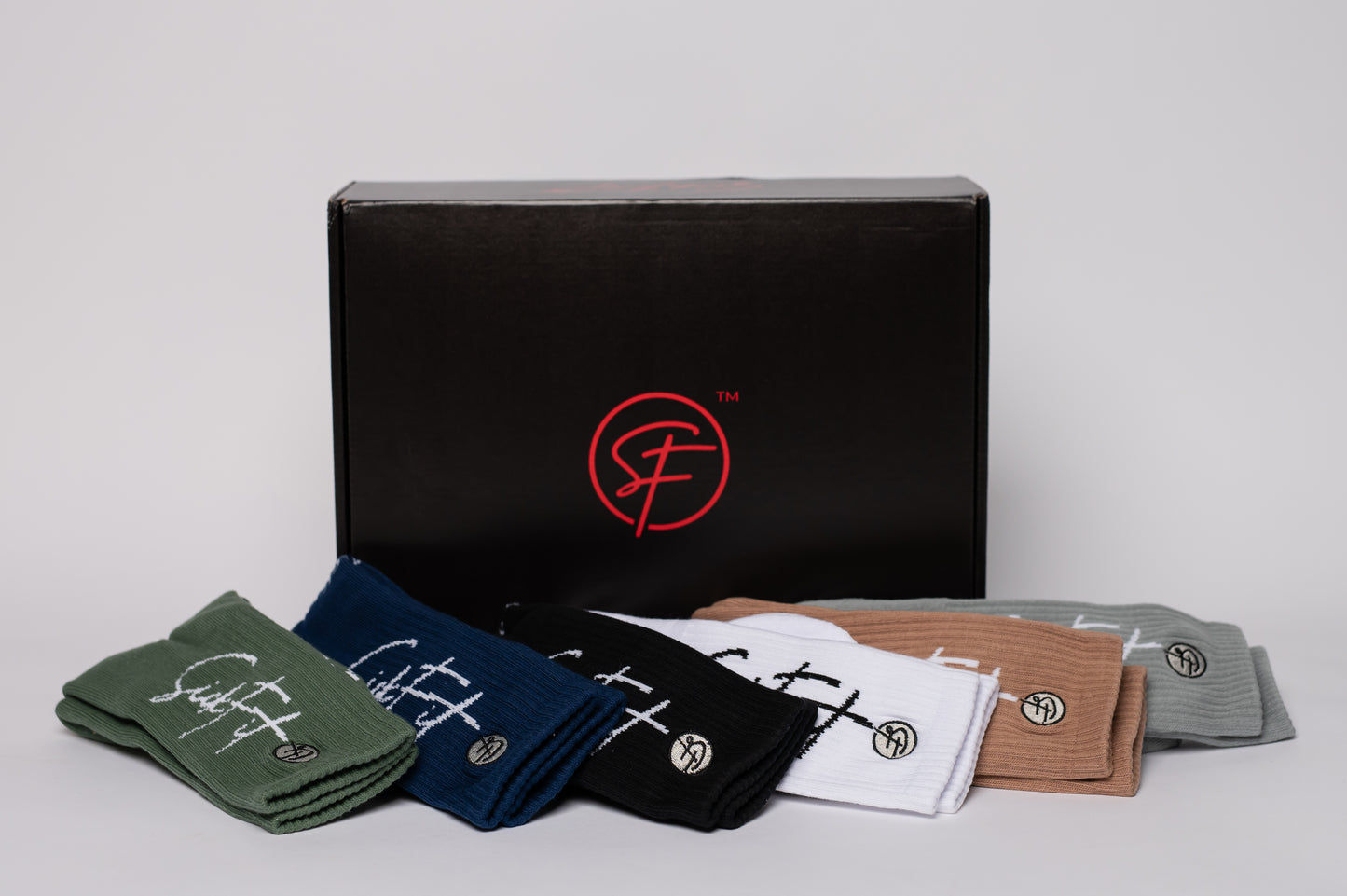 Collection of crew compression socks with a branded box on a light gray background