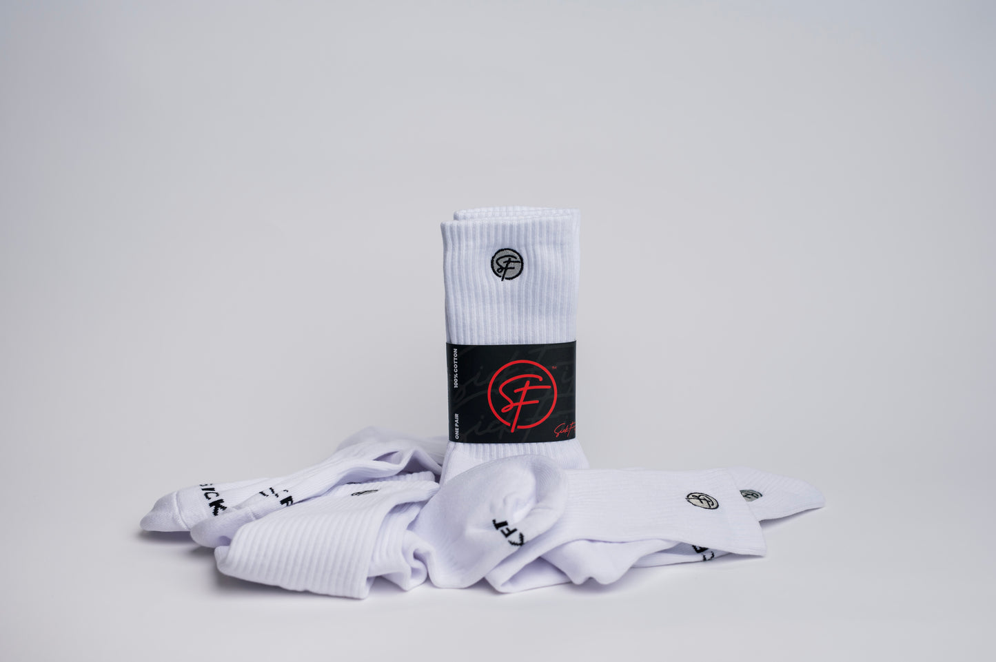 White SickFit compression socks with a red and black logo, placed on a white surface.