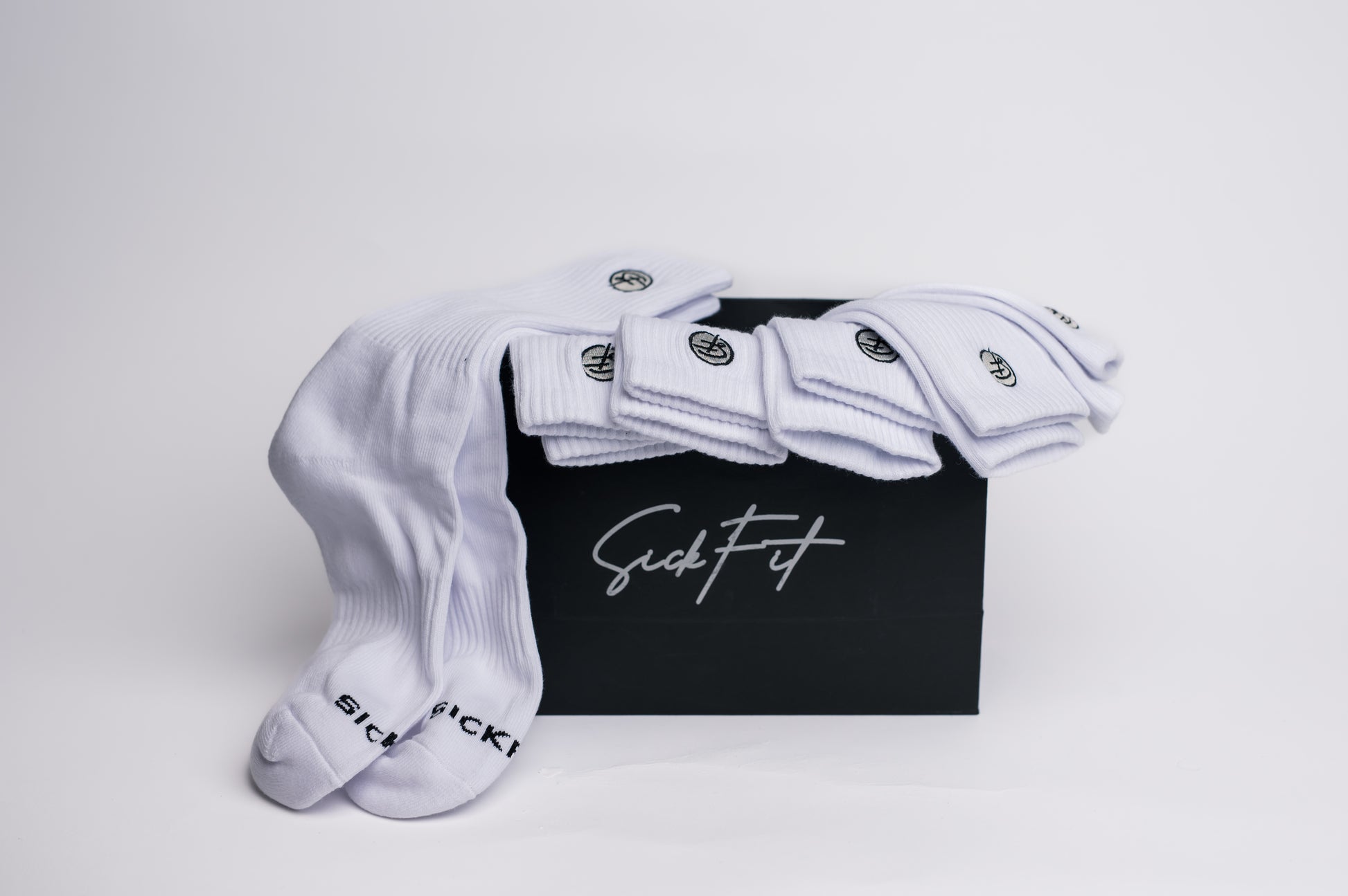 A set of white crew compression socks with the logo 'SickFit' on the ankle area, displayed on a black background.