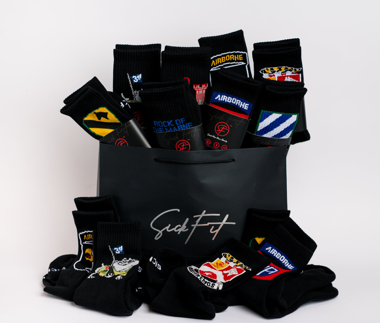 A collection of black crew compression socks for military division with various colorful logos and designs, displayed in a black gift box with the brand name 'Sickfit' visible.