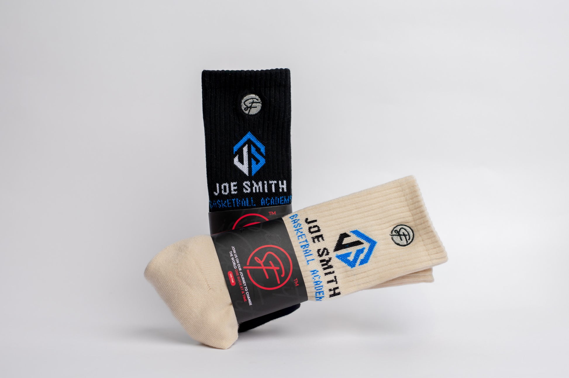 Pair of beige crew compression socks with black and blue branding on a white background