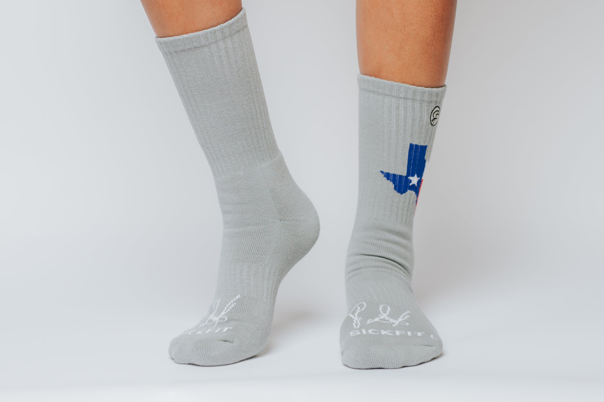 Gray compression socks with a blue and red design of the state of Texas on a white background