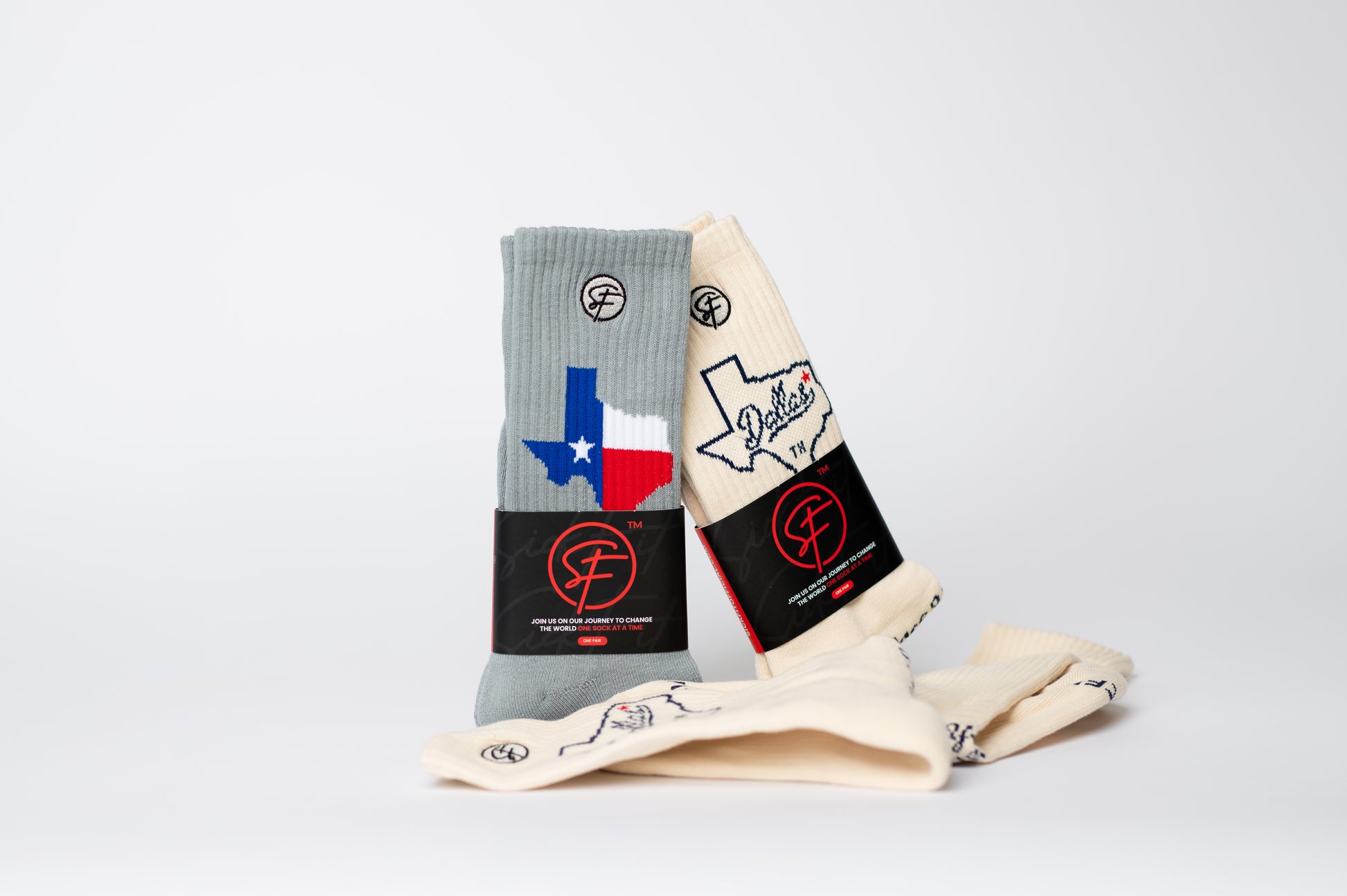 Two pairs of compression socks with Texas designs on a light gray background