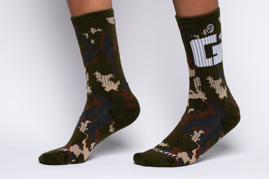 Green crew compression camouflage socks with a logo on a white background