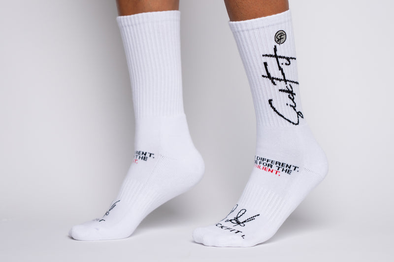 White crew compression socks with black text on a gray background