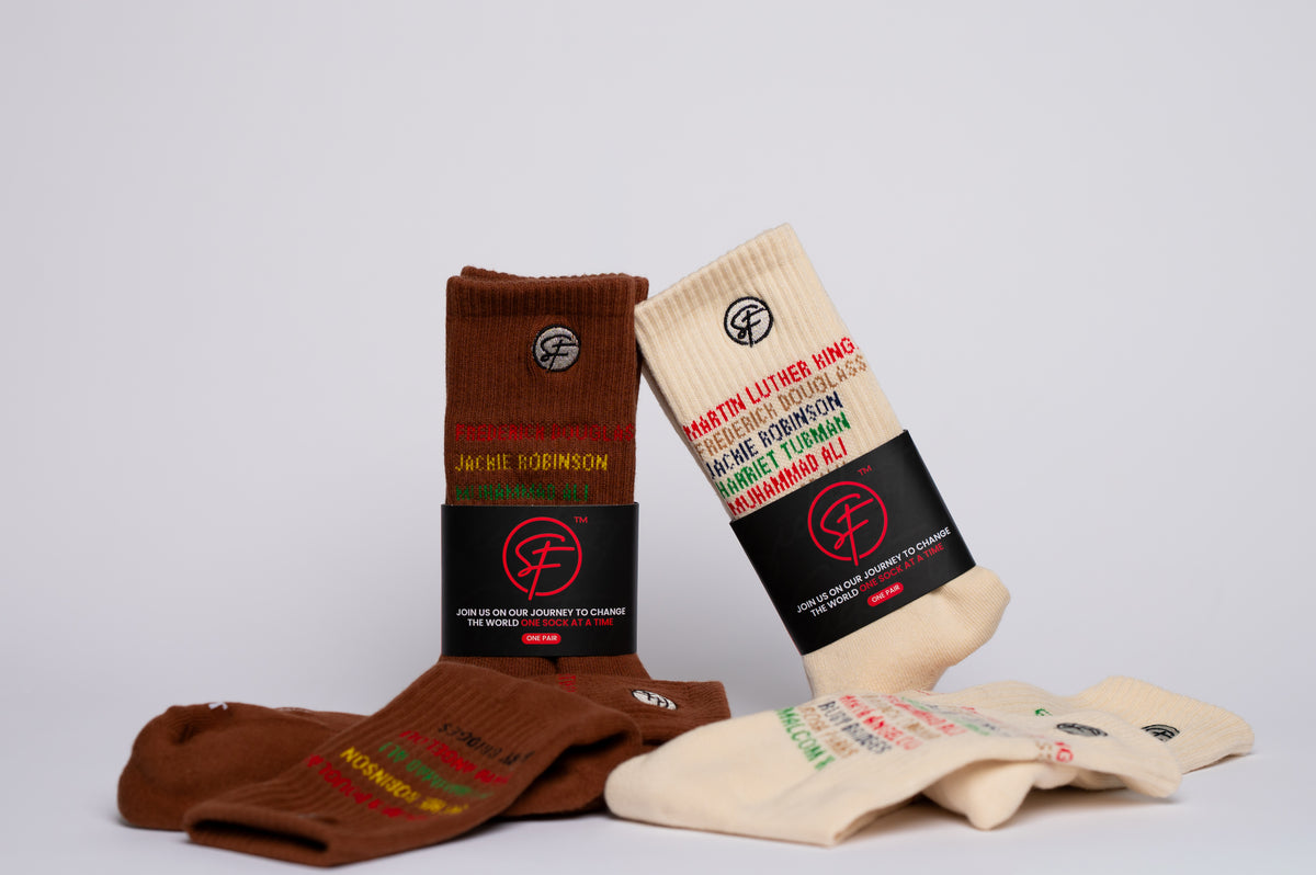 Two pairs of history branded crew socks, one brown and one beige, with visible branding on a light gray background.