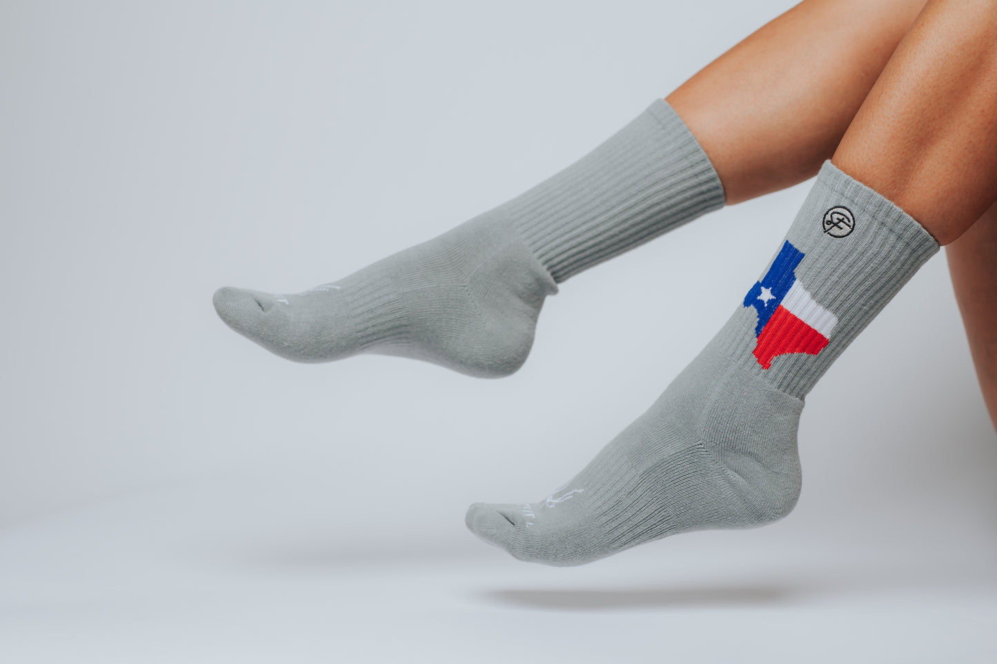 Gray Crew Compression socks with a Texas flag design on a light gray background