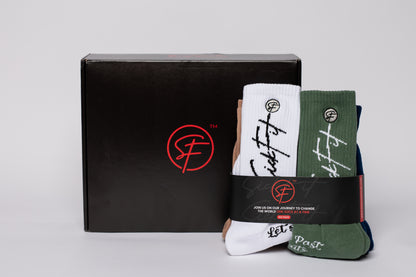 Set of crew compression socks with branding in front of a black box with a logo on a light gray background