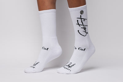 White crew compression socks with black text on a neutral background