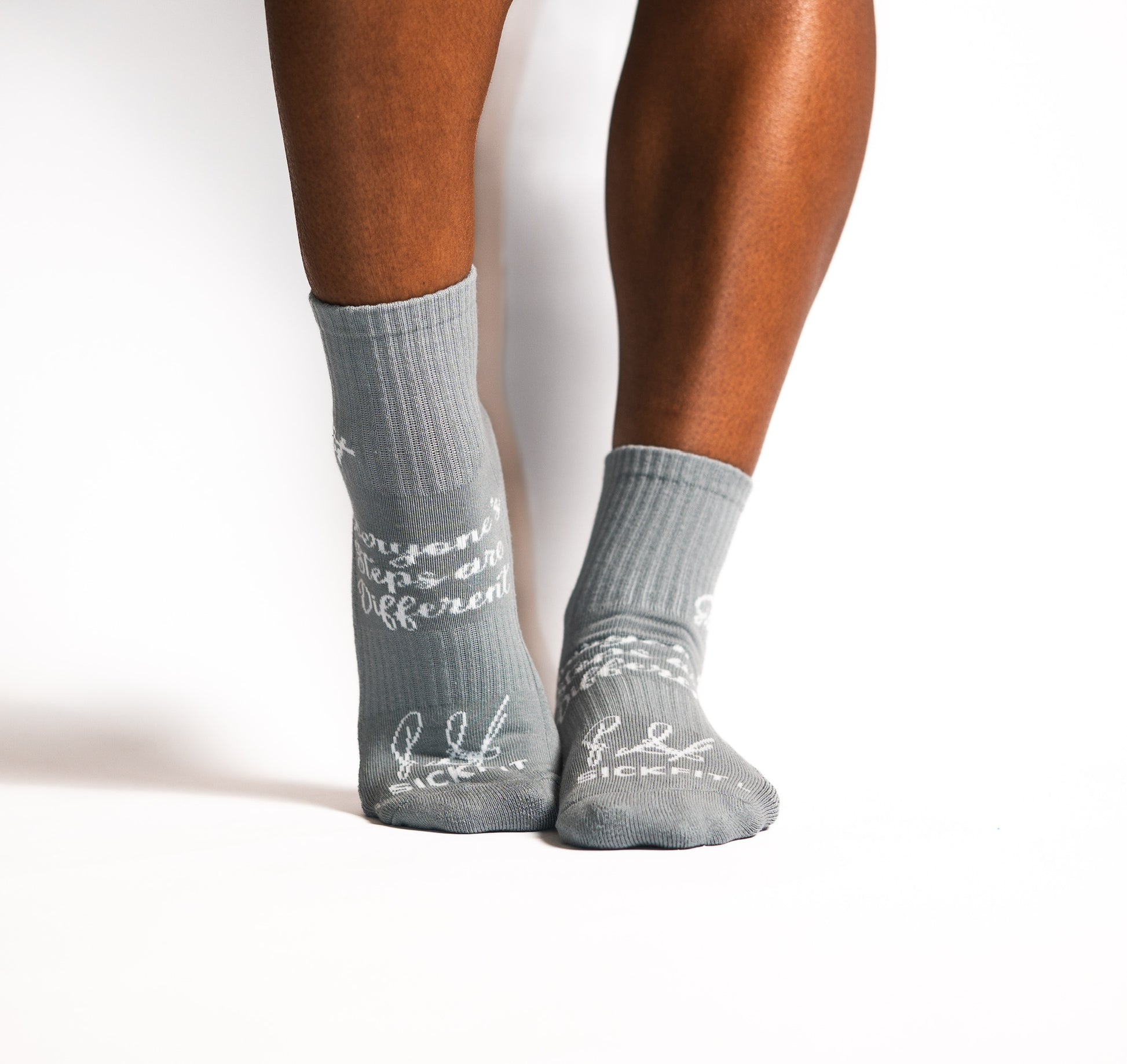 Gray compression socks with text worn by a person on a white background