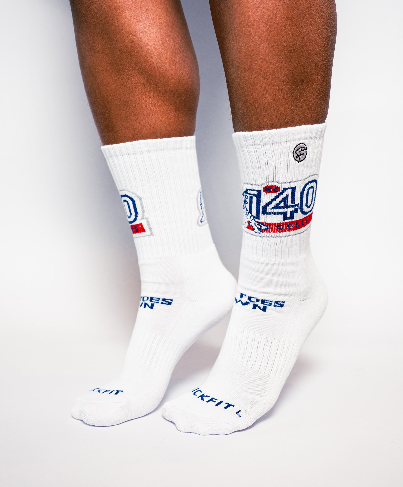 White socks with blue and red text worn by a person on a light gray background